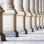 Closeup bases row of marble columns. Symbols of integrity, stability, and trustworthiness. Closeup row of classical marble columns. Detail of Mlynska colonnade Karlovy Vary Czech republic establish 1881, this is the biggest colonnade in Karlovy Vary. Full frame horizontal composition with copy space